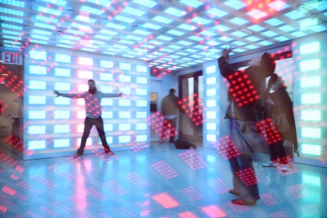 Double exposure photo of the room with motion activated lights. A tourist takes pictures. Top of the Rock at the Rockefeller Center.