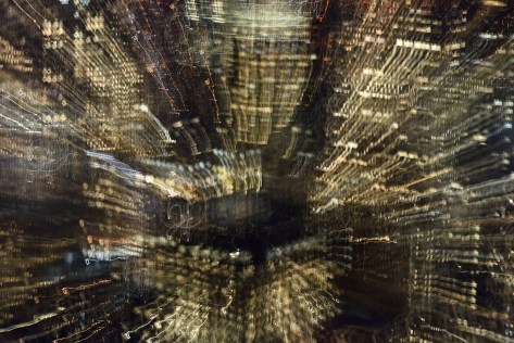 Long exposure photo with zooming and panning showing trails of city lights.