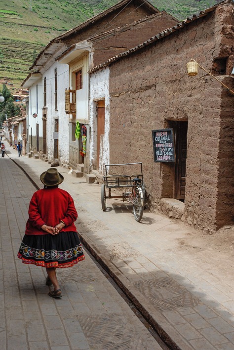 Photo of a woman walking in front of a bakery near Cuzco.