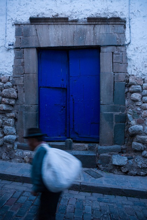 Photo of a man in front of a blue door in Cuzco.