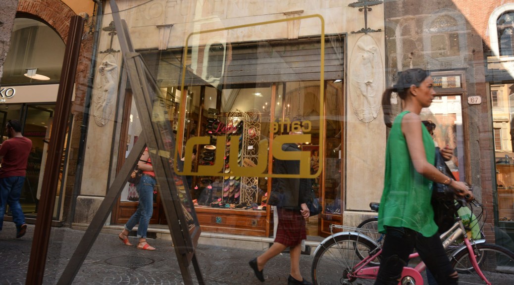Image of street life in front of a perfume shop in Luca, Italy. Photo by Eduardo Libby,